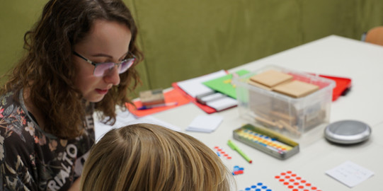 Studierende sitz mit Schüler an Tisch