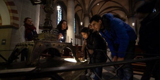 Schüler*innen stehen im Essener Münster vor dem Altar und betrachten diesen.