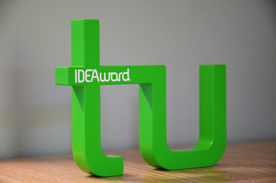 Foto zeigt das Logo des Lehrpreises: grüner Schriftzug der TU mit weißem Schriftzug IDEAward